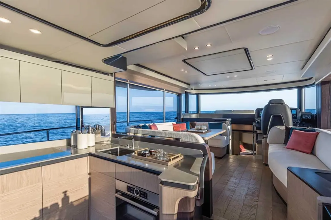 Stylish yacht interior featuring a modern kitchen and lounge with ocean views, highlighting comfort and luxury.